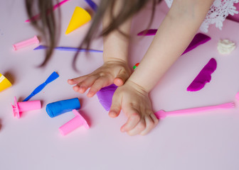 Child hands playing with colorful clay. Homemade plastiline. Girl molding modeling clay. Homemade clay. Child playing and creating from play dough.