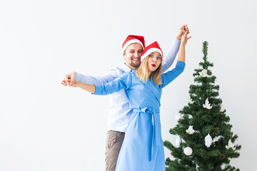 Holidays and celebration concept - Young couple celebrating Christmas at home