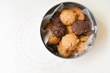 Homemade cookies in round tin box on white background