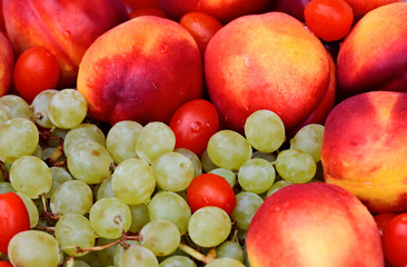 Fresh ripe nectarine and grape fruits and some tomatoes in a heap after washing