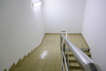 The concept of the interior of an urban building. Photo of a staircase with metal railing between floors. - 305866864