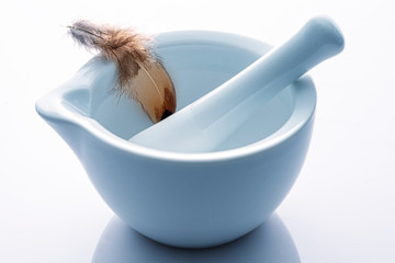 Zarte Feder in einem Mörser mit Klöppel