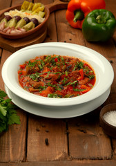 roasted lamb in tomato sauce with bell peppers, tomato garnished with herbs