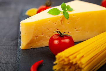 Spaghetti, cheese and chili peppers on a black background.