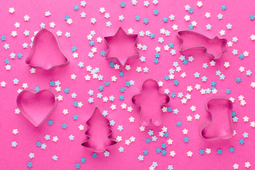 pink background with cookies cutter and white and blue snowflakes