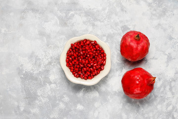 Pomegranate seeds with pomegranate on concrete background