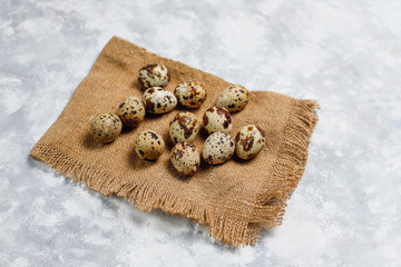 Quail eggs on a white-grey concrete  background