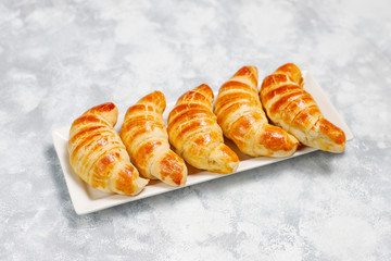 Fresh tasty homemade croissants on grey-white background. French pastry