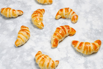 Fresh tasty homemade croissants on grey-white background. French pastry