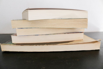 Raccolta di vecchi libri accatastati su un tavolo nero, educazione e letteratura