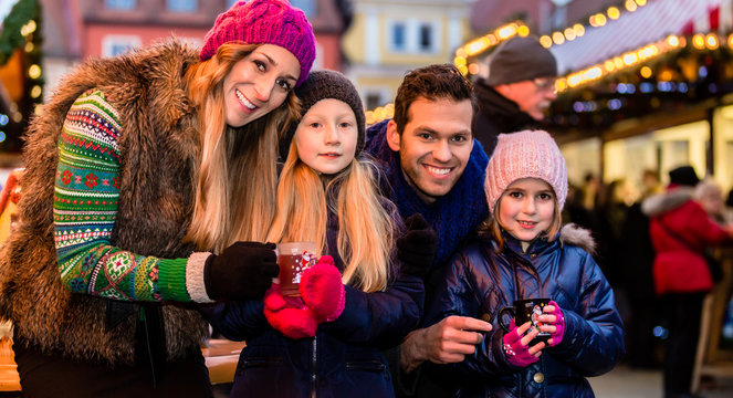 Family Drinking Mulled Wine On Christmas Market