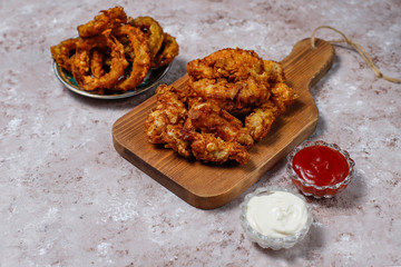 Chicken strips with ketchup and mayonnaise. top view on brown light background.