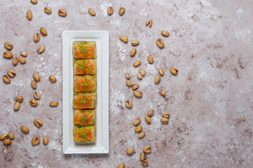 Traditional Turkish Pastry Dessert Baklava with pistachio nuts on concrete background.