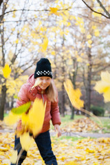 Girl throws autumn leaves in the Park