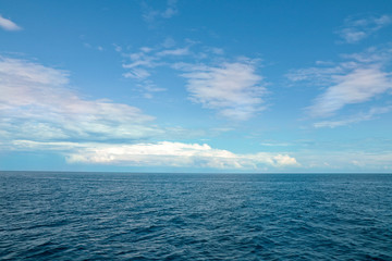 Obraz premium Pejzaż morski. Błękitne niebo z chmurami i spokojne morze.