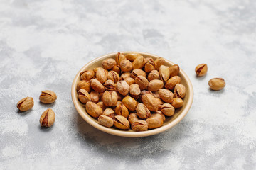 Fresh pistachios in ceramic plates.top view