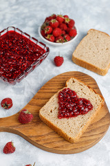homemade raspberry jam with fresh raspberries on concrete background,top view