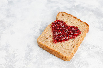 homemade raspberry jam with fresh raspberries on concrete background,top view