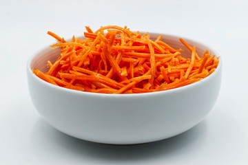 Carrots sliced in a white bowl, isolated on white background