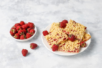 Homemade raspberry crumble bar on plate on light background