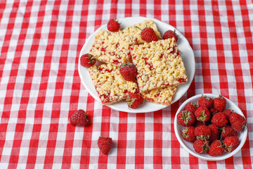 Homemade raspberry crumble bar on plate on light background