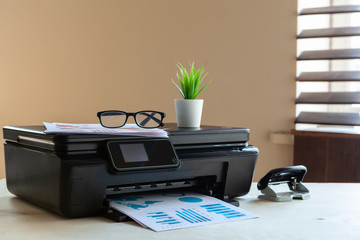 Front view of a black printer machine on a table