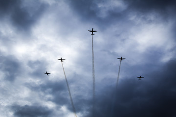 Aerobatic aircraft fly over cloudy clouds