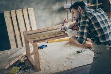Profile side back rear photo of focused workman restore hobby wooden furniture slab table measure...