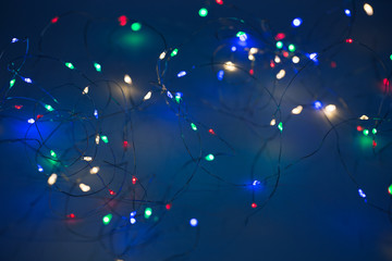 Christmas lights on dark blue background with copy space. Decorative garland