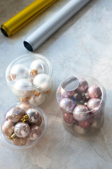 Modern set of various glass Christmas balls in box on marble background. New Year decor, vertical format