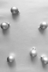 Modern silver glass Christmas balls on shiny background, above. New Year decor, vertical format