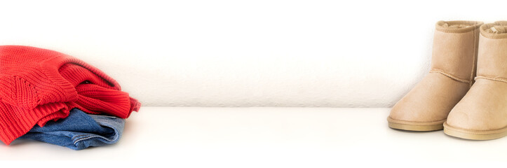 Red warm sweater,blue jeans and  beige boots on white large background for banner.  Warm comfortable clothes for Autumn Winter season.