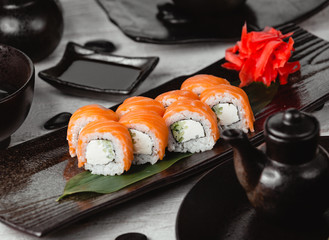 sushi rolls with cucumber covered with salmon