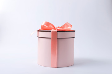 Silk bow and ribbon, pink round gift box on the grey surface.Present box made of pastel colored...