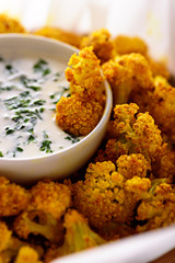 vertical image of cauliflower with sour cream sauce in bowl on white background. dietary garnish concept