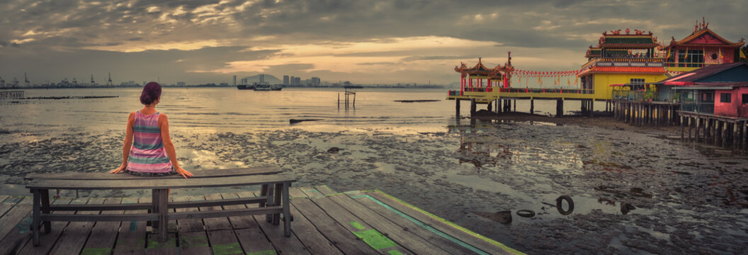 Tourist sitting at Yeoh jetty, Penang, Malaysia. Panorama