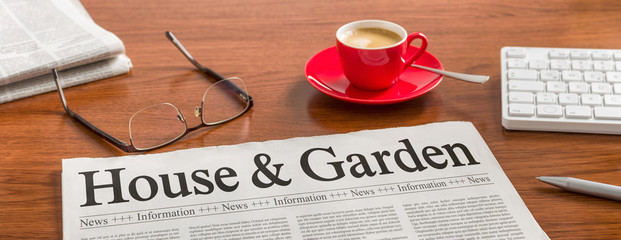 A newspaper on a wooden desk - House and Garden