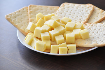 Crackers and cheese on a white plate. Selective focus.
