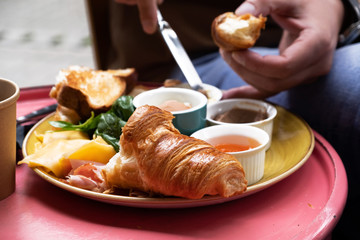 Blond-haired man having breakfast in a cafe with fresh organic products
