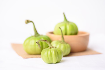 Close up of organic raw green tomato on a white background