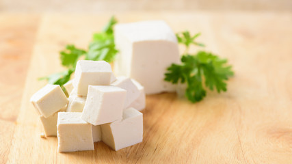 Sliced tofu on wooden background, vegetarian food