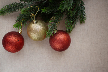 Obraz na płótnie Canvas gold and red balls on a xmas tree, on a beige background with a place for Christmas greetings