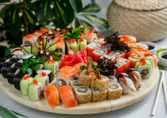 sushi set with hot and cold rolls on wood platter