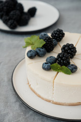 cheesecake New York with fresh berries and a slice on a plate