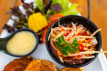 Spicy mango salad packed in a black bowl, looks delicious.