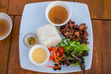 Pork, steamed rice, served with a salad of organic vegetables.