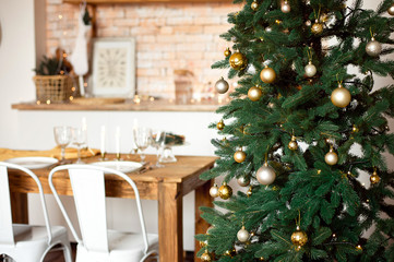 Beautiful festively decorated Scandinavian-style room, a festive table with a table and a Christmas tree with gifts under it.