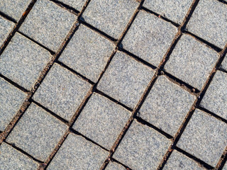 Granite dirty paving stones in the city. Road from paving stones for background and texture. The...