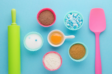 ingredients for baking and kitchen tools on blue background, flat lay