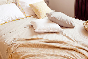 Christmas apartment decor, Scandinavian cozy home decor, bed with warm knitted blankets next to the Christmas tree. Lights and garlands